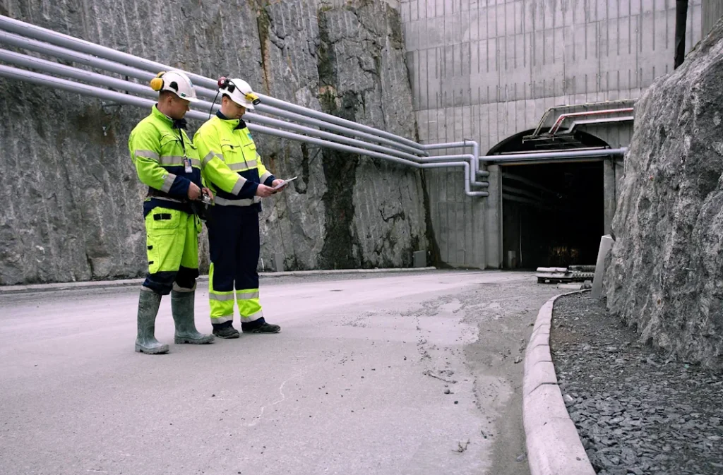 Två arbetare vid infarten till ett slutförvar i berget