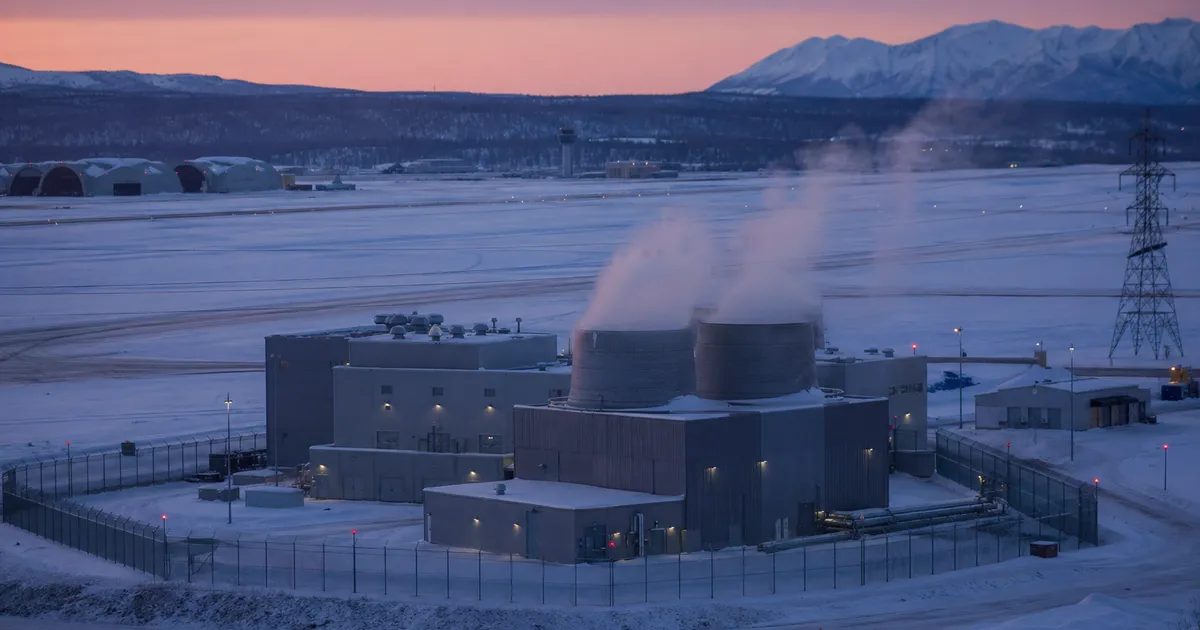 Industriell kärnreaktoranläggning i snötäckt militär miljö med ångmoln