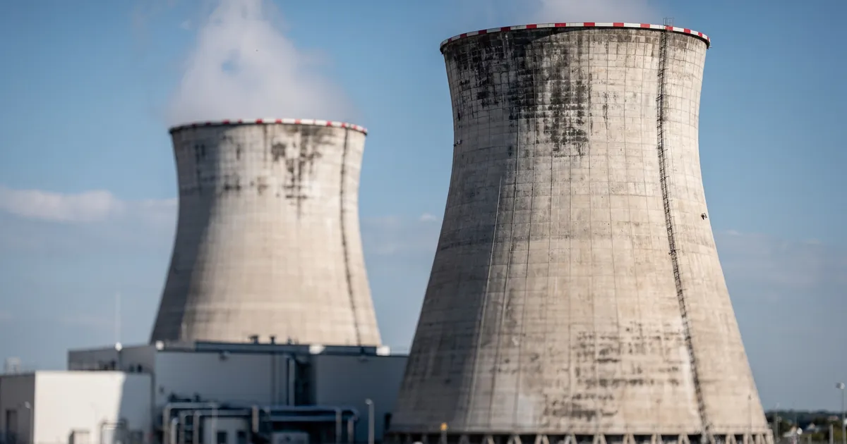 Kärnkraftverk med kylande torn mot blå himmel, industriell arkitektur