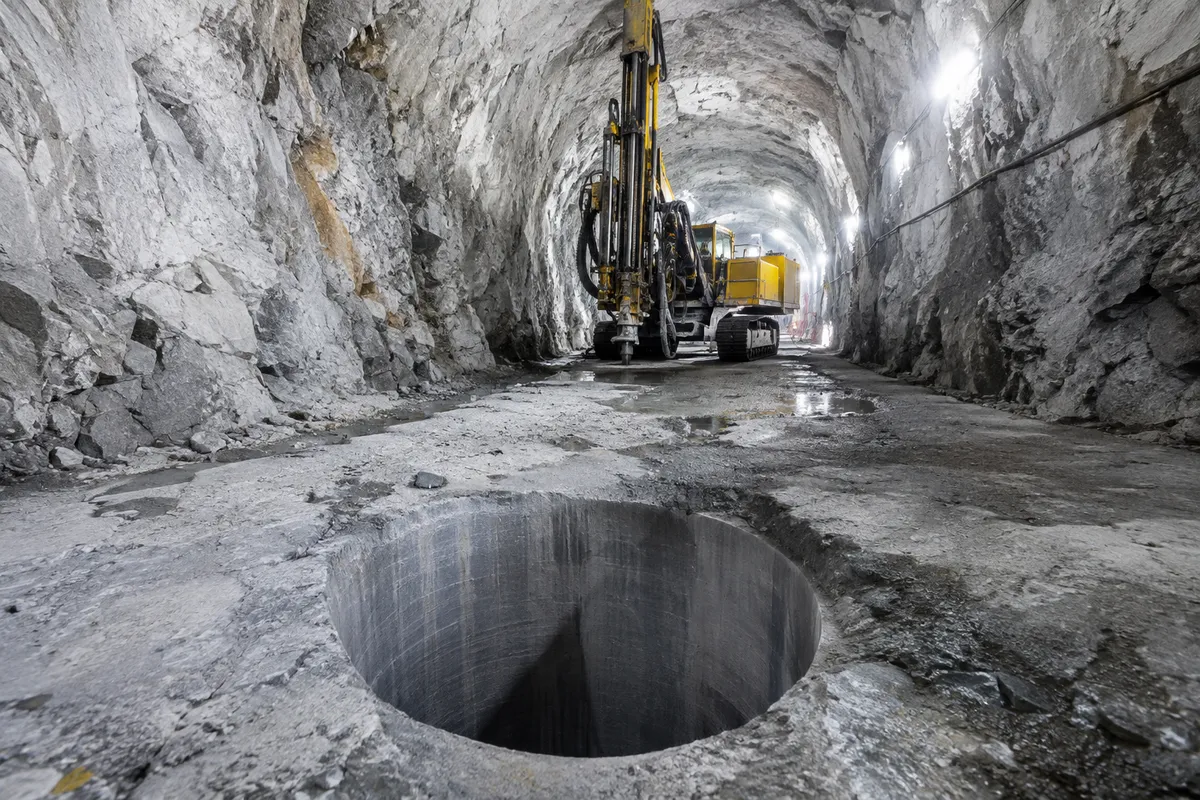 Deponeringstunnel i granitberg med ett lodrätt borrat hål i golvet för en kopparkapsel