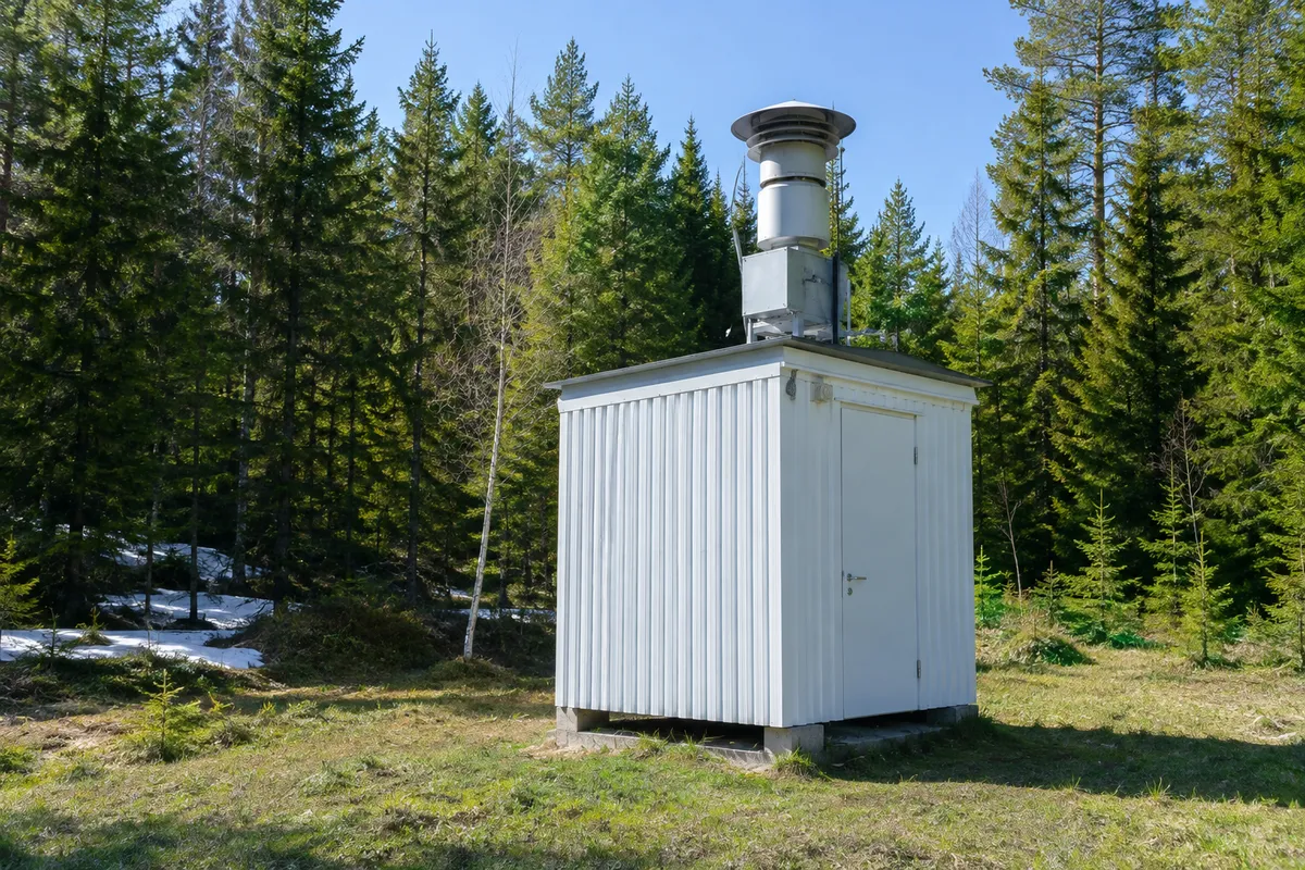 Mätstation för radioaktiva ämnen i luften vid en barrskog i Sverige en vårdag