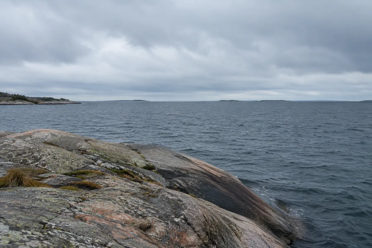 Öppet hav i Östersjön utanför släta granitklippor i skärgården en grå höstdag